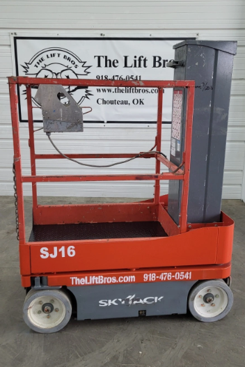 Orange Skyjack SJ16 mast lift, rear three-quarter view, platform lowered on the base