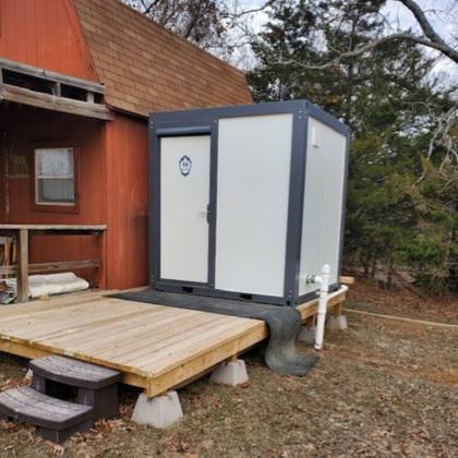 Bastone shower restroom bathroom customer installation on an outside deck with plumbing