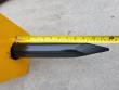 Tape measure laid along the breaker's black moil point chisel, about 11 inches exposed past the housing
