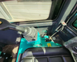 MH13RX mini excavator cab: gray pilot joystick on the teal console, padded black seat and rubber floor mat