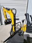 FF15 from the operator seat: yellow FF Industrial boom with the bucket raised, travel levers, joystick and treadplate floor