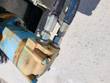 Blue hydraulic drive motor and two supply hoses mounted at the end of the angle broom