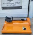 Orange Wolverine flail mower from the side with black excavator mount bracket and hydraulic motor