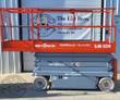 Orange SkyJack SJIII 3226 scissor lift, platform lowered with guardrails and roll-out deck extension, gray scissor stack