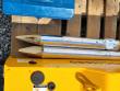 Two foil-wrapped chisels with pointed and wedge tips resting on the SDCH680's yellow body beside the tool box