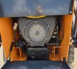 QB-480 mini skid steer RATO 739cc gas engine, cooling fan shroud and muffler behind the bucket linkage