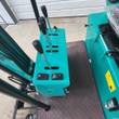 AGT MH12RX controls: teal console with travel and boom levers, work-light rocker switches and the rubber floor mat