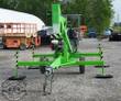 Green towable boom lift folded for transport, gas engine, outriggers down and tow coupler