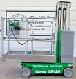 Green Genie GR-20 vertical mast lift, stowed, side view with platform rails and Lift Bros backdrop