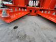 Orange tree shear's two open shear arms with bolt-on hardened blades and hydraulic hoses above