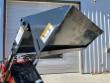 4-in-1 bucket raised and tilted on a mini skid steer's arms, clamshell jaw open, falling-blade warning decal