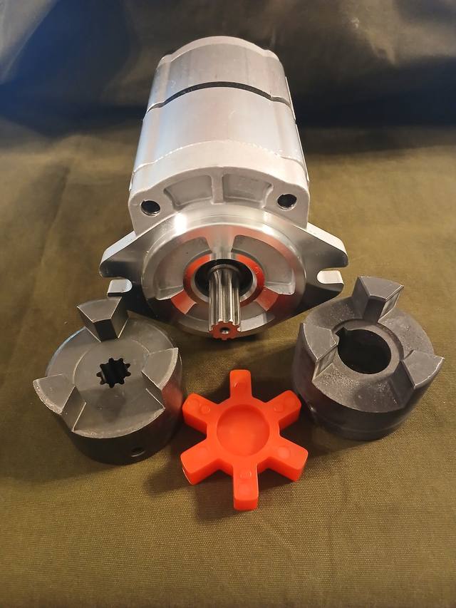 Hydraulic gear pump with splined shaft, shown with two jaw coupler hubs and orange spider insert