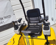 FF15 operator station: black vinyl seat between twin joystick pods, two travel levers in front, throttle and hour meter