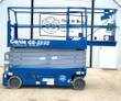 Blue Genie GS-3232 electric scissor lift, platform lowered, guardrails up, extension deck and solid cushion tires