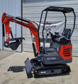MX15RX mini excavator with orange boom, digging bucket and thumb, gray backfill blade and rubber tracks