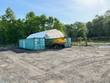 White dome-roof shelter spanning two teal shipping containers
