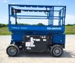 GS-2669 RT rough terrain scissor lift, blue, platform lowered with folding guardrails on four-wheel-drive lug tires