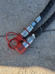 Flat-faced hydraulic quick couplers with a red dust cap and spiral-wrapped hoses