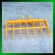 Yellow excavator root rake, seven curved tines on a tubular frame with twin pin bosses on the spine