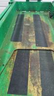 Scissor lift platform floor close-up, green with non-slip traction strips