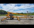 Yellow Haulotte 3632T towable boom lift, boom stowed over the trailer with outriggers down