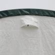 Triangular vent flap in the white fabric wall, below the green ridge trim cap