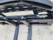 Pallet fork carriage from above: slotted backrest, hose runs, couplers and the two fork hangers