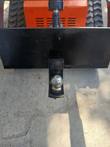Quick attach plate with ball mount in its 2-inch receiver, front view on an orange tracked mini skid steer