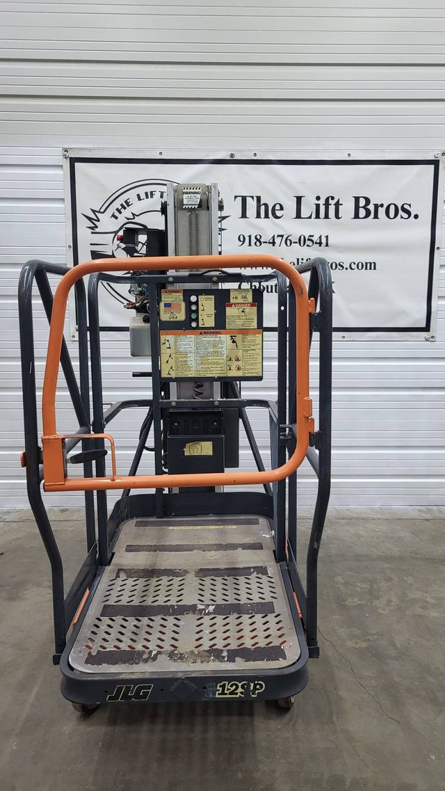 JLG 12SP push-around mast lift, lowered, end view of the platform with swing gate, mast and warning decals