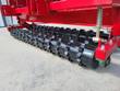 No till seed drill toothed packer roller under the red frame with a spring-loaded tension arm