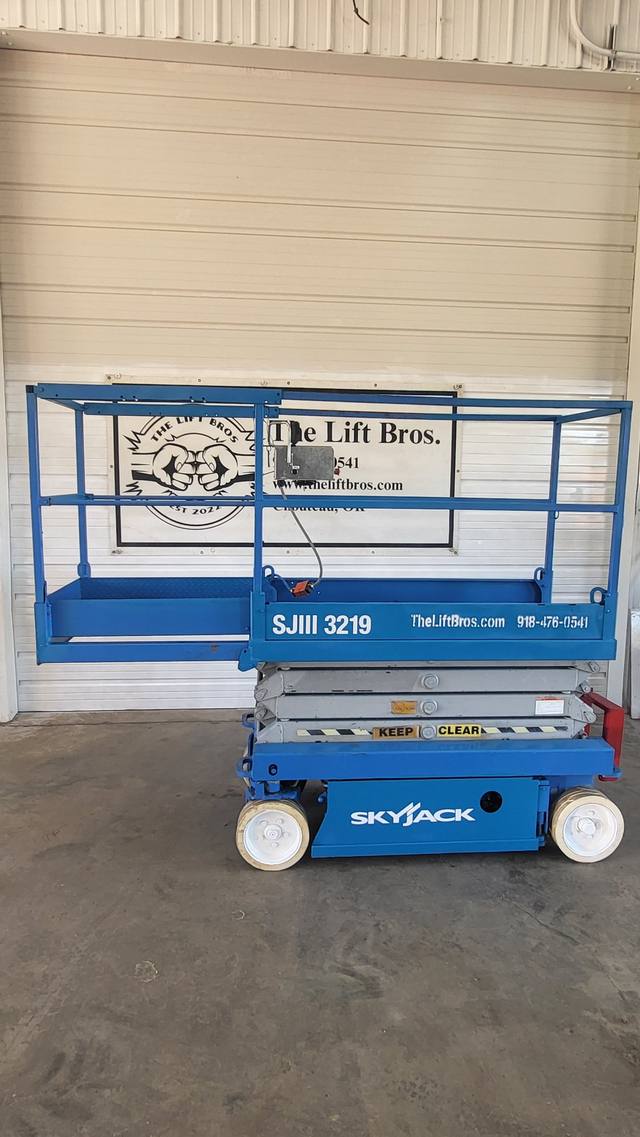 Blue Skyjack SJIII 3219 electric scissor lift, stowed, side view with platform extension out