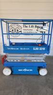 Blue Skyjack SJIII 3219 scissor lift, stowed, opposite side with control box and red entry step