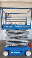 Skyjack SJIII 3219 scissor lift with the platform raised partway, gray scissor arms exposed