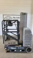 Gray JLG 20MVL vertical mast lift, stowed, side view with platform, mast and drive wheel