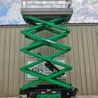 JLG 3246ES scissor lift raised to full height, green scissor stack under silver platform