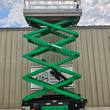 JLG 3246ES scissor lift raised to full height, green scissor stack under silver platform