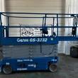 Genie GS-3232 electric scissor lift, blue with gray scissor stack, stowed, side view