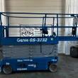 Genie GS-3232 electric scissor lift, blue with gray scissor stack, stowed, side view