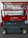 Red and gray Skyjack 3219 electric scissor lift, stowed, side view with platform rails and Skyjack decals