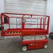 Snorkel S3219E electric scissor lift, orange, stowed, side view with platform rails and white scissor stack