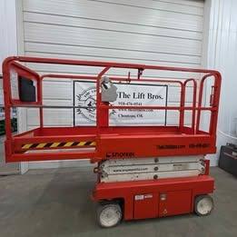 Snorkel S3219E electric scissor lift, orange, stowed, side view with platform rails and white scissor stack