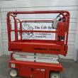 Snorkel S3219E electric scissor lift, orange, stowed, left side view showing platform and base