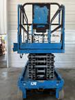 Genie GS-4047 scissor lift stowed, end view of the platform, folded scissor stack and chassis