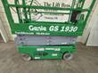 Green Genie GS-1930 scissor lift side view: gray scissor stack, chassis controls and wheels