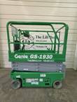 Green Genie GS-1930 scissor lift side view, stowed, with guardrails and gray scissor arms