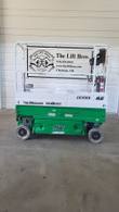 Green and white JLG 1930ES scissor lift, stowed, opposite side view with platform rails and control box