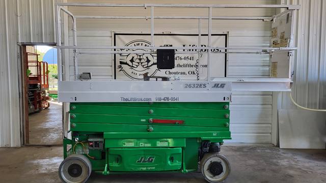 Green and gray JLG 2632ES electric scissor lift, stowed, side view