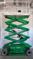 Green JLG 2632ES electric scissor lift raised high, side view with hydraulic pump and cylinder