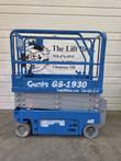 Blue Genie GS-1930 electric scissor lift, stowed, left side with platform guardrails and control box