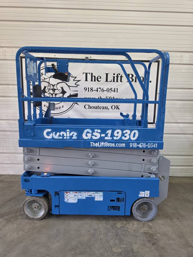 Blue Genie GS-1930 electric scissor lift, stowed, left side with platform guardrails and control box